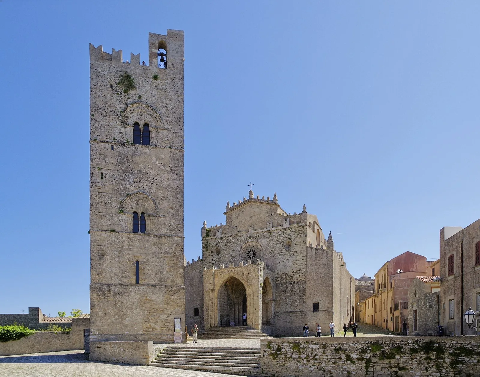 La Chiesa Madre di Erice con il campanile merlato staccato dalla facciata gotica, sotto un cielo azzurro